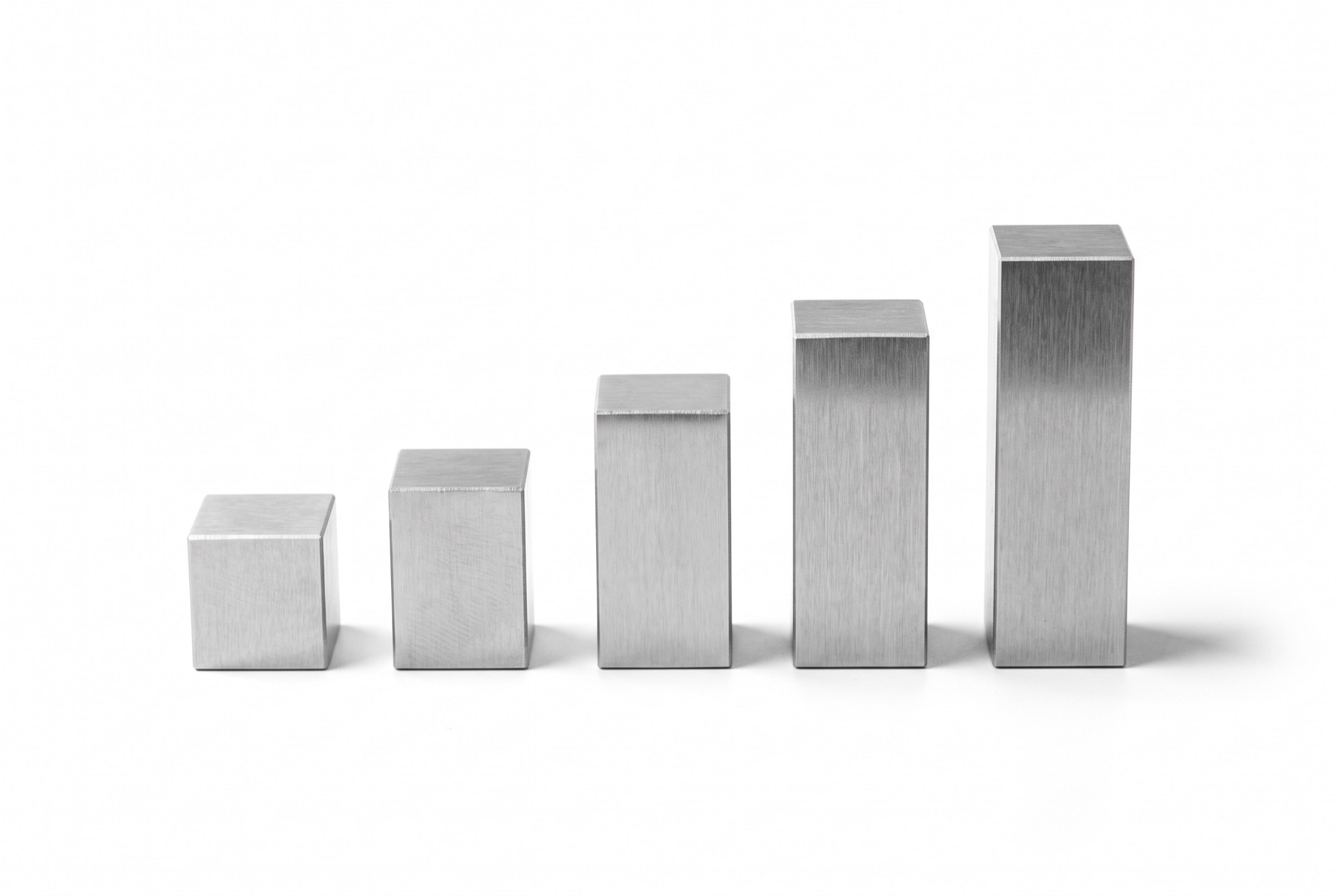 Five steel gauge blocks of increasing height standing in a row on a white surface, each one taller than the last.